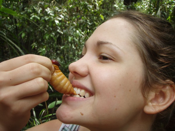 Девушка кушает личинку